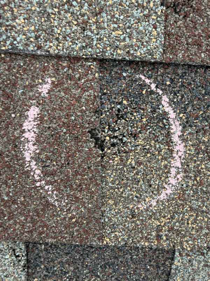 Actual inspection close-up of a chalk-marked shingle location
